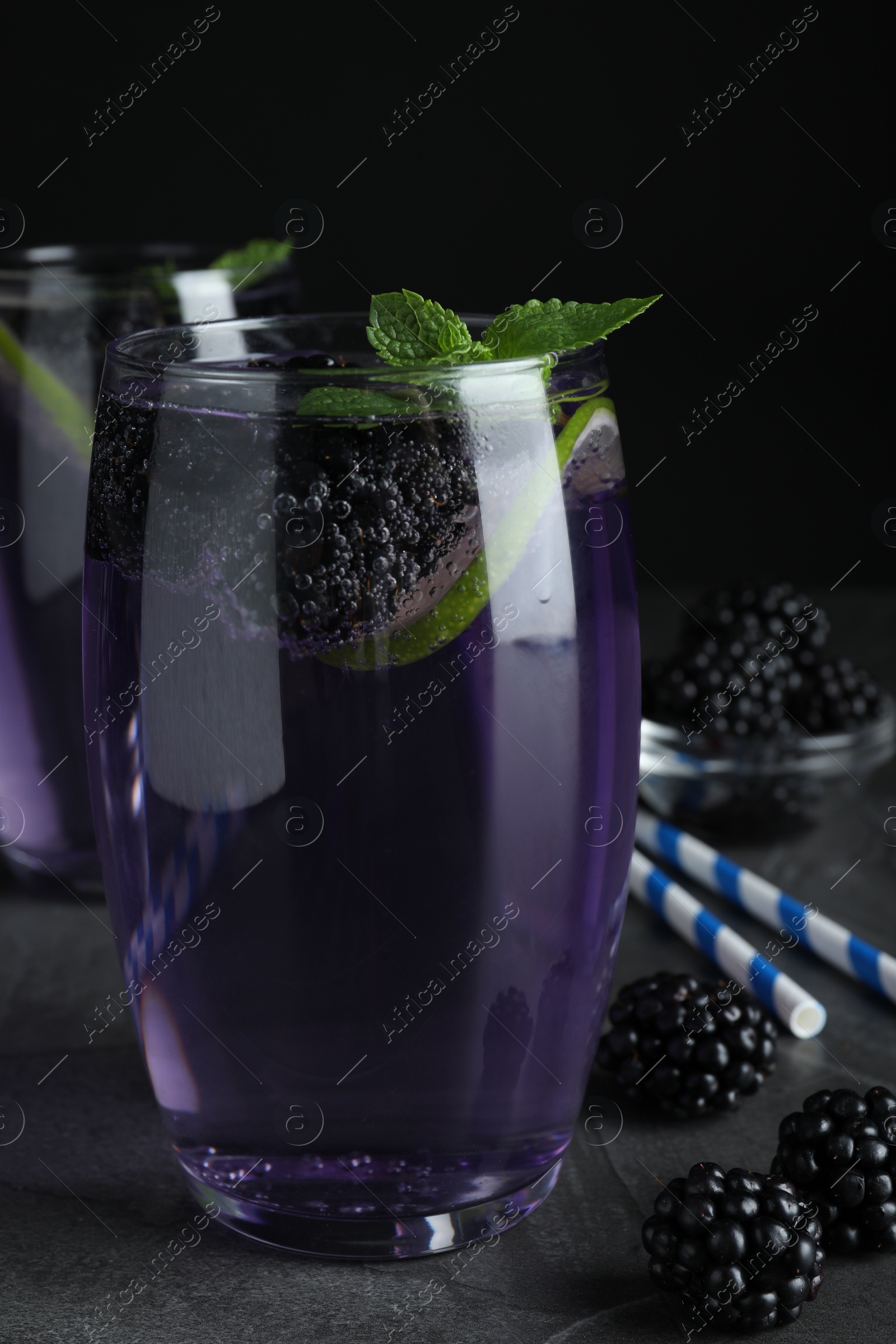 Photo of Delicious blackberry lemonade made with soda water on grey table