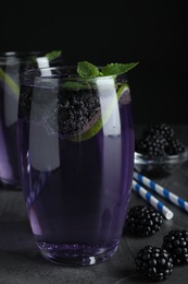 Photo of Delicious blackberry lemonade made with soda water on grey table
