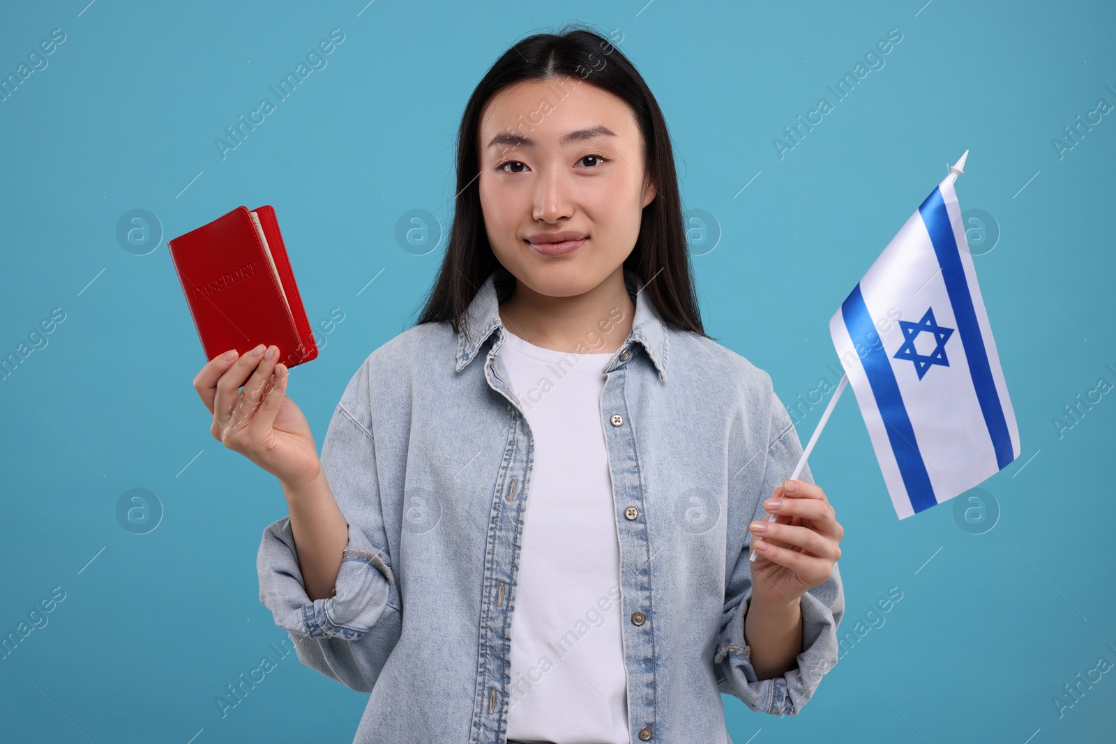 Photo of Immigration to Israel. Woman with passport and flag on light blue background