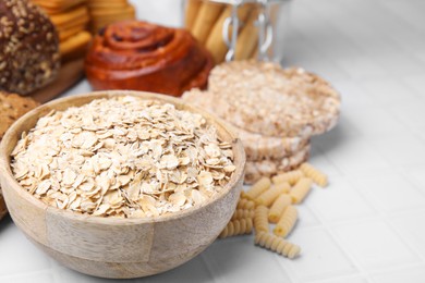 Photo of Different gluten free products on white tiled table, closeup