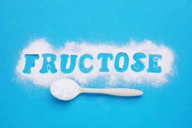 Photo of Word Fructose made of powder and spoon on light blue background, flat lay