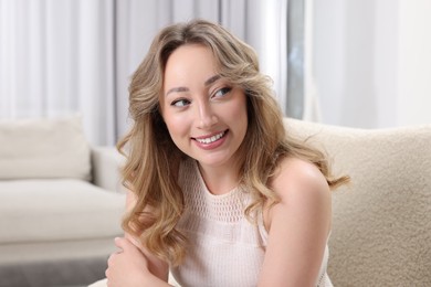 Portrait of smiling woman with curly hair at home