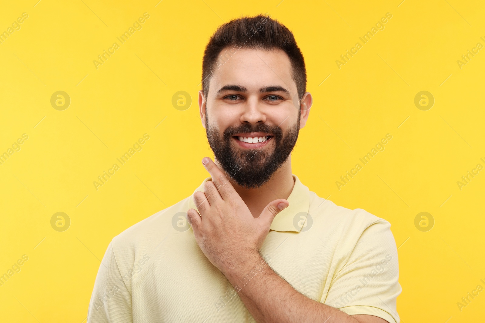 Photo of Man with clean teeth smiling on yellow background