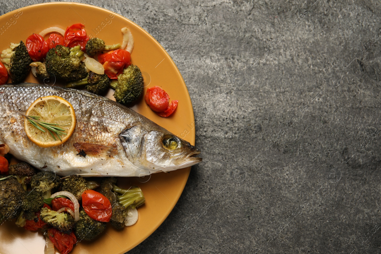 Photo of Delicious baked fish and vegetables on grey background, top view. Space for text