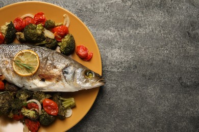 Photo of Delicious baked fish and vegetables on grey background, top view. Space for text