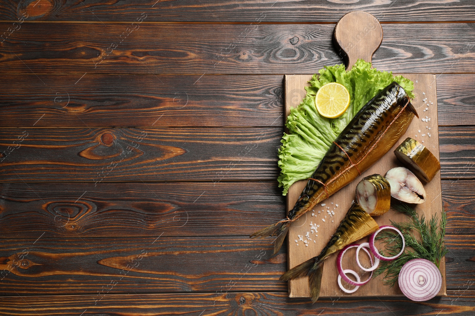 Photo of Tasty smoked fish on wooden table, top view. Space for text