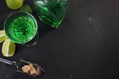 Photo of Absinthe, spoon, brown sugar and lime on black table, flat lay with space for text. Alcoholic drink