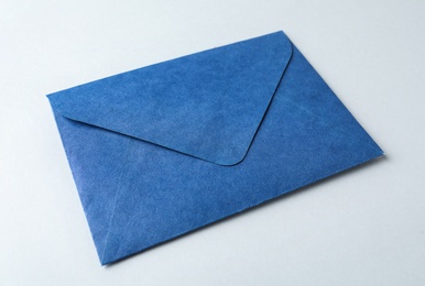 Photo of Blue paper envelope on light background, closeup. Mail service