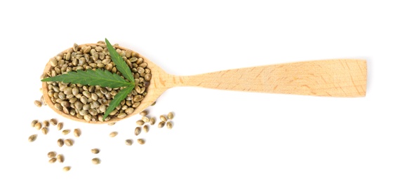 Photo of Spoon with hemp seeds and green leaf on white background, top view