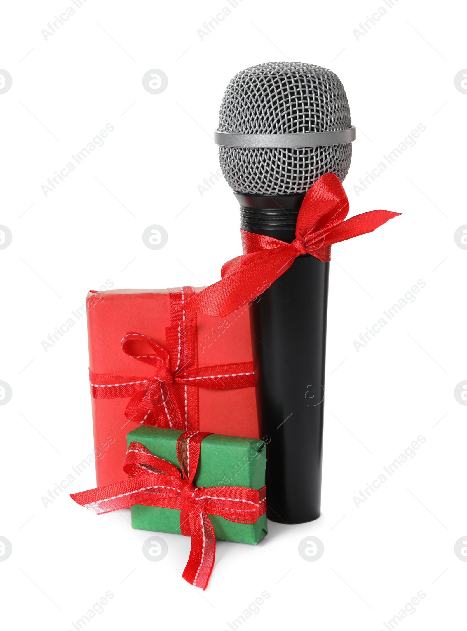 Photo of Microphone with red bow and gift boxes on white background. Christmas music