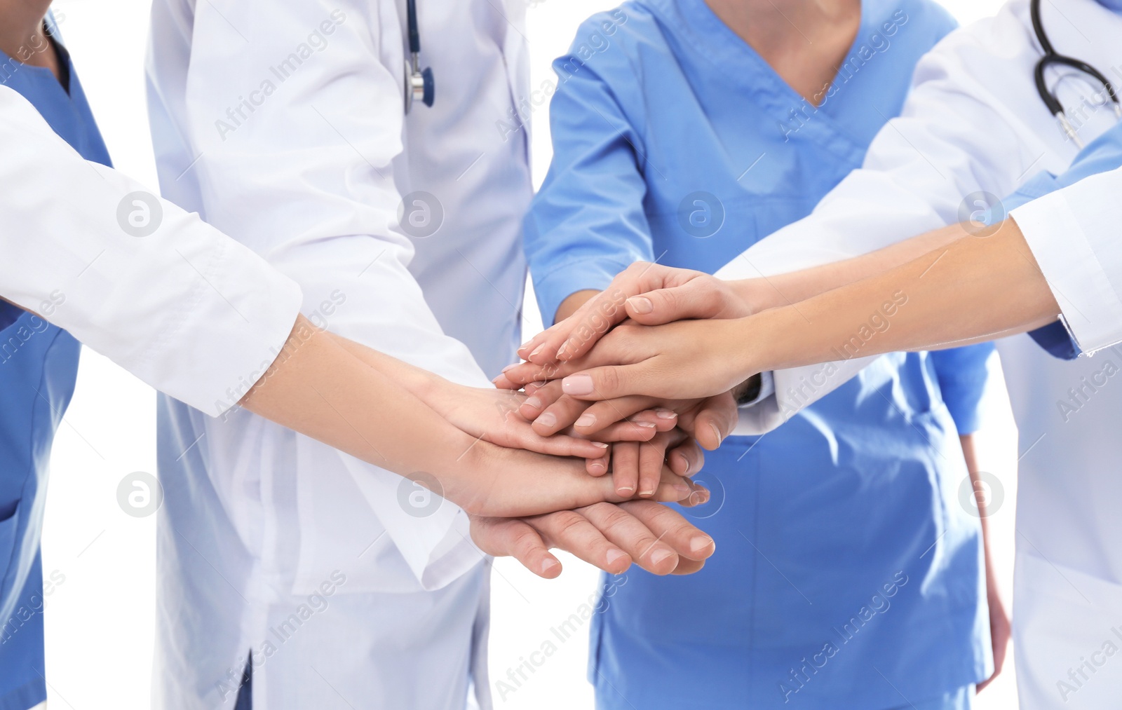 Photo of Team of medical doctors putting hands together on white background, closeup. Unity concept
