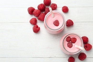 Image of Yummy raspberry smoothie on white wooden table, flat lay 