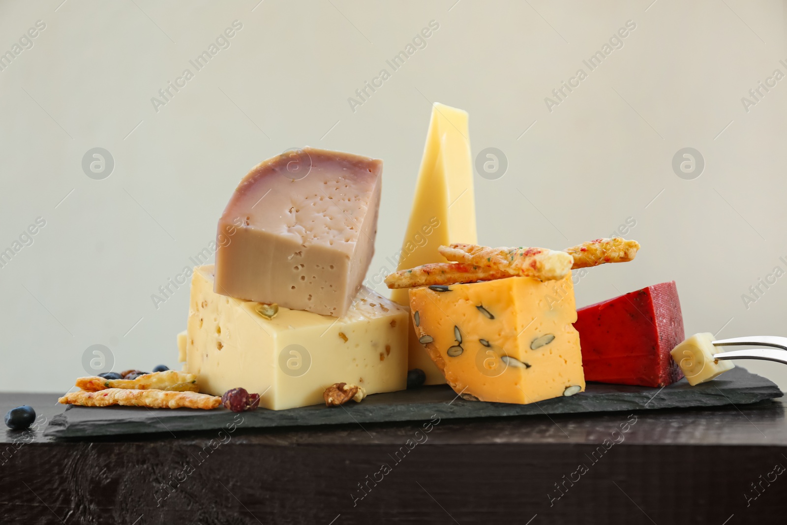 Photo of Different types of delicious cheeses on slate plate