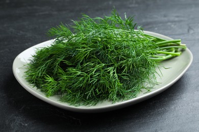 Plate of fresh dill on black table