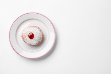 Photo of Hanukkah donut with jelly and powdered sugar on white background, top view. Space for text
