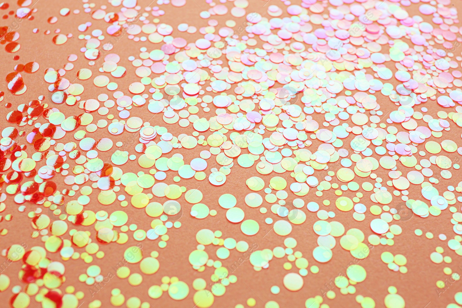 Photo of Shiny bright orange glitter on beige background