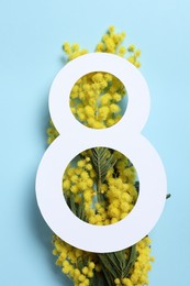 Photo of 8 March greeting card design with yellow mimosa flowers on light blue background, top view. Happy International Women's Day