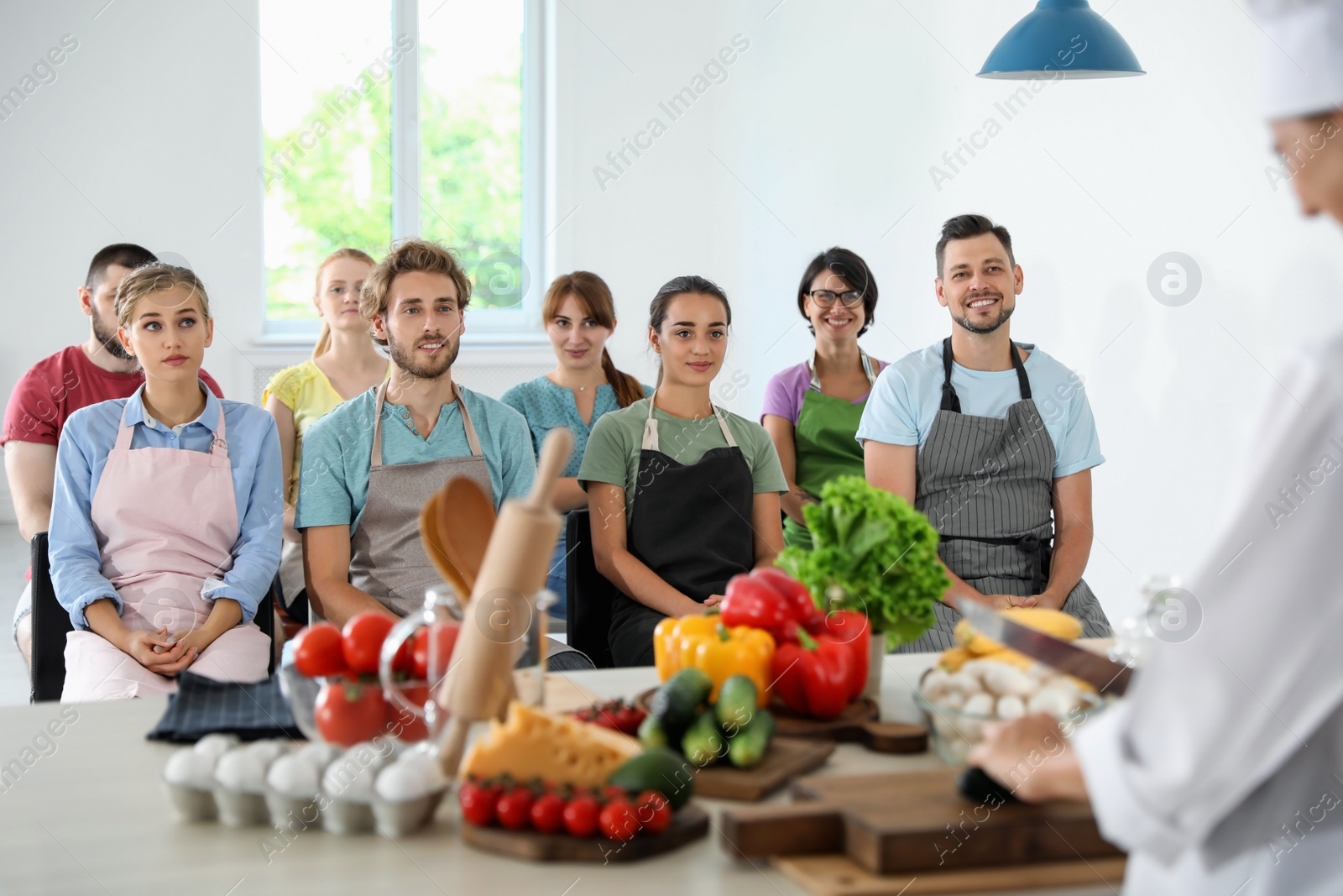 Photo of Group of people and female chef at cooking classes