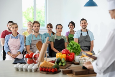 Group of people and female chef at cooking classes