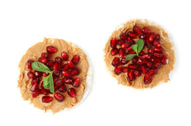 Puffed rice cakes with peanut butter, pomegranate seeds and mint isolated on white, top view