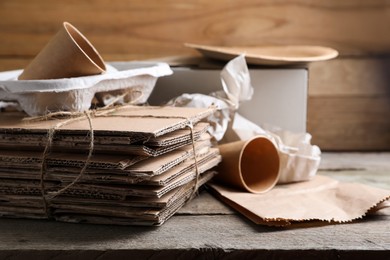 Photo of Different waste paper on wooden table, closeup. Space for text