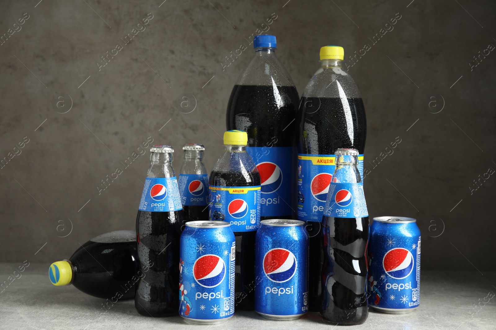 Photo of MYKOLAIV, UKRAINE - FEBRUARY 9, 2021: Many different bottles and cans of Pepsi on grey table