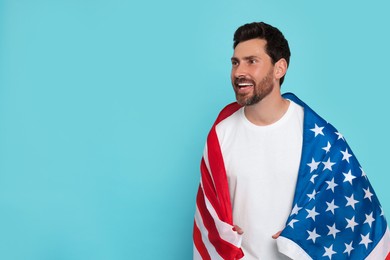 Photo of 4th of July - Independence Day of USA. Happy man with American flag on light blue background, space for text