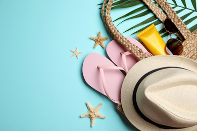 Flat lay composition with beach objects on light blue background. Space for text