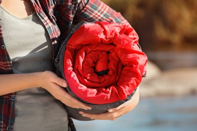 Photo of Female camper with sleeping bag outdoors, closeup