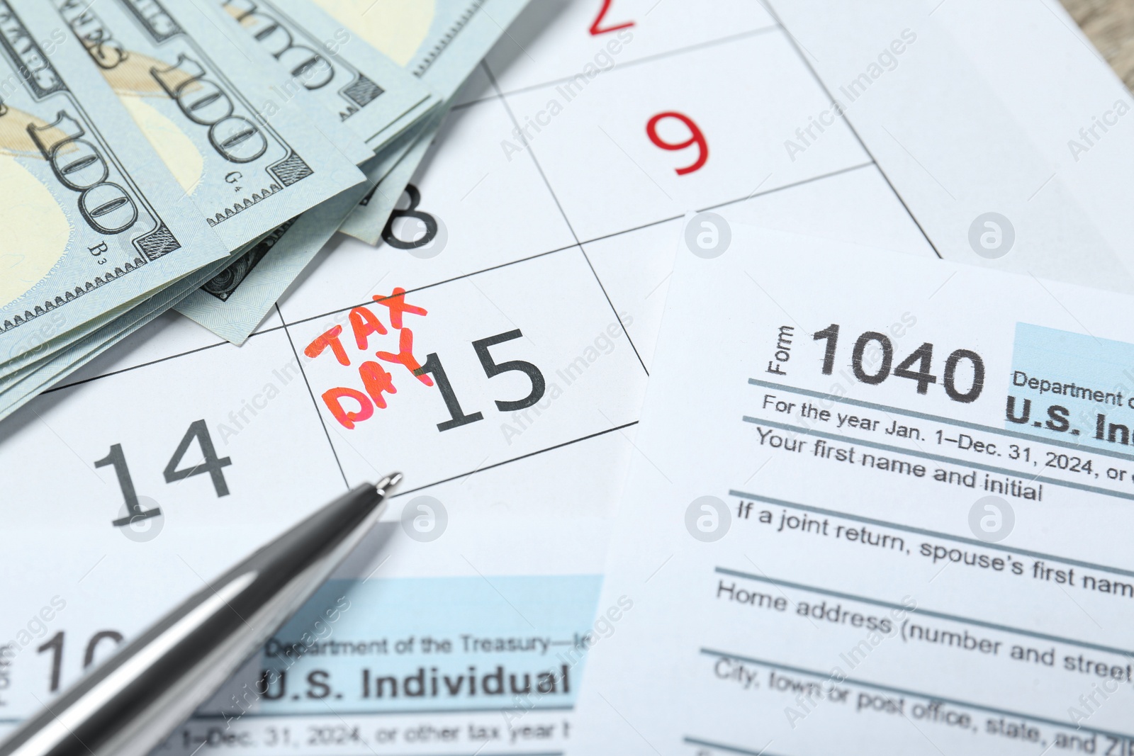 Photo of Tax day. Calendar with date reminder, documents, dollar banknotes and pen on table