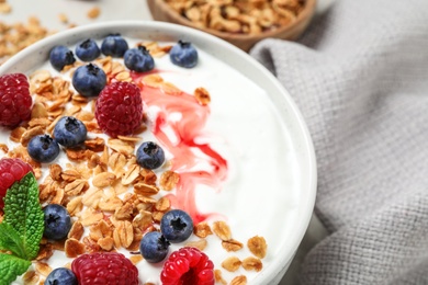 Photo of Tasty homemade granola with yogurt and berries on table, closeup. Healthy breakfast