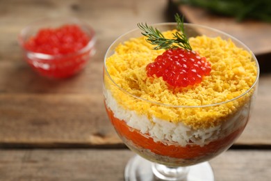 Photo of Traditional russian salad Mimosa served on wooden table, closeup.