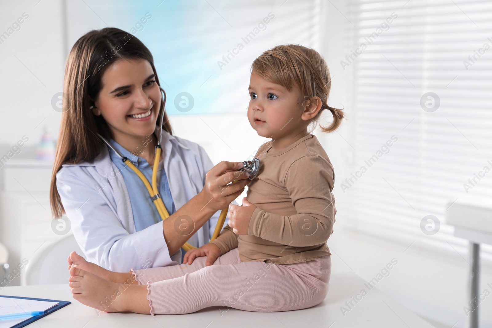 Photo of Pediatrician examining baby with stethoscope in clinic