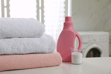 Clean towels and detergents on table in laundry room