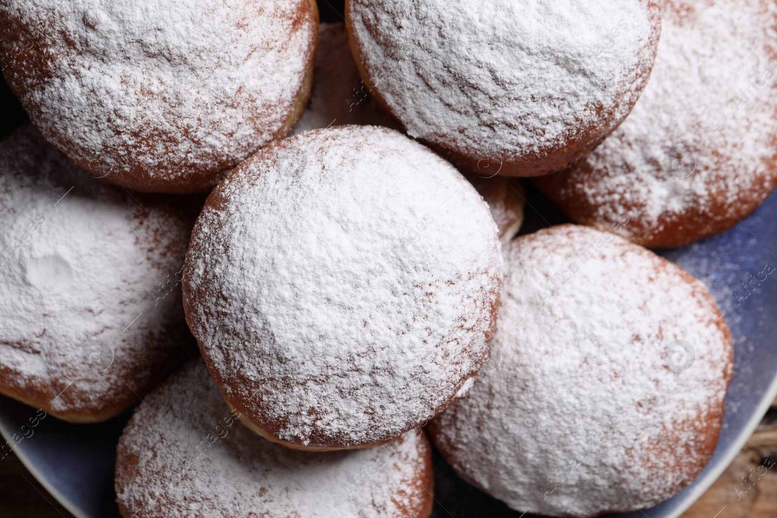 Photo of Delicious sweet buns with powdered sugar on plate, top view