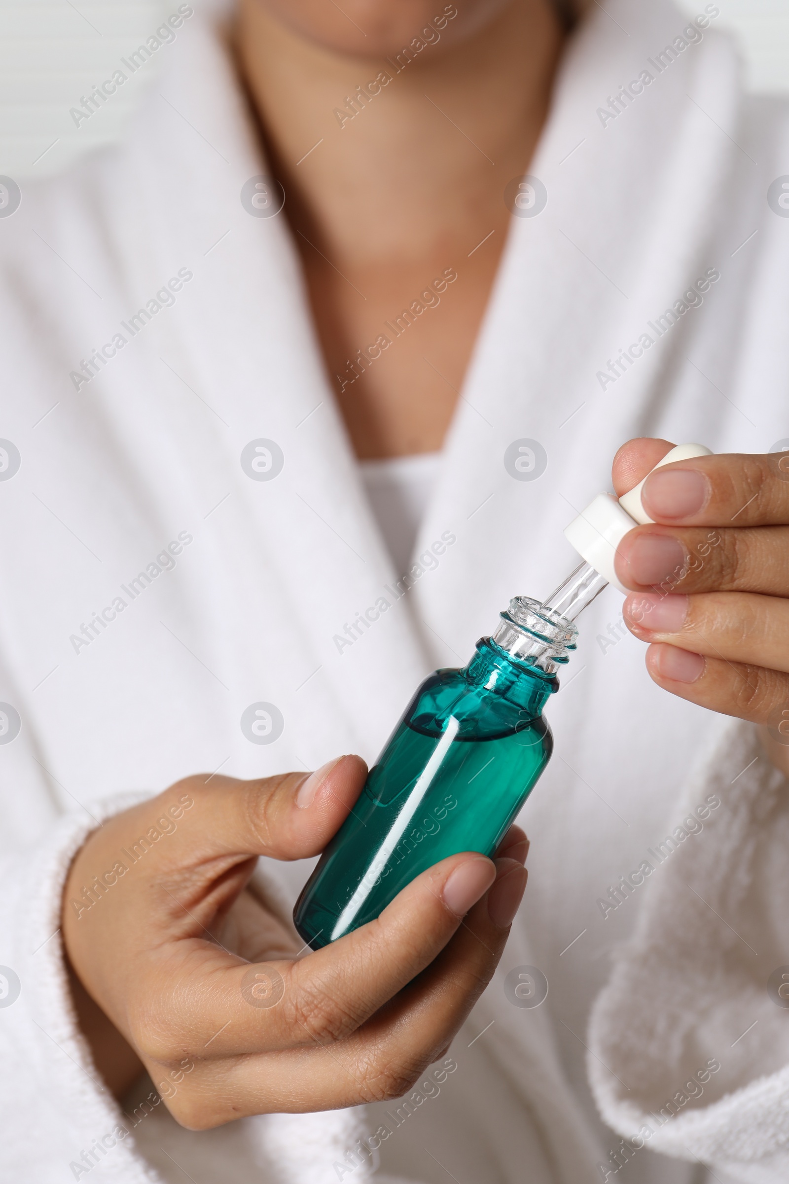 Photo of Woman with bottle of cosmetic serum and dropper, closeup