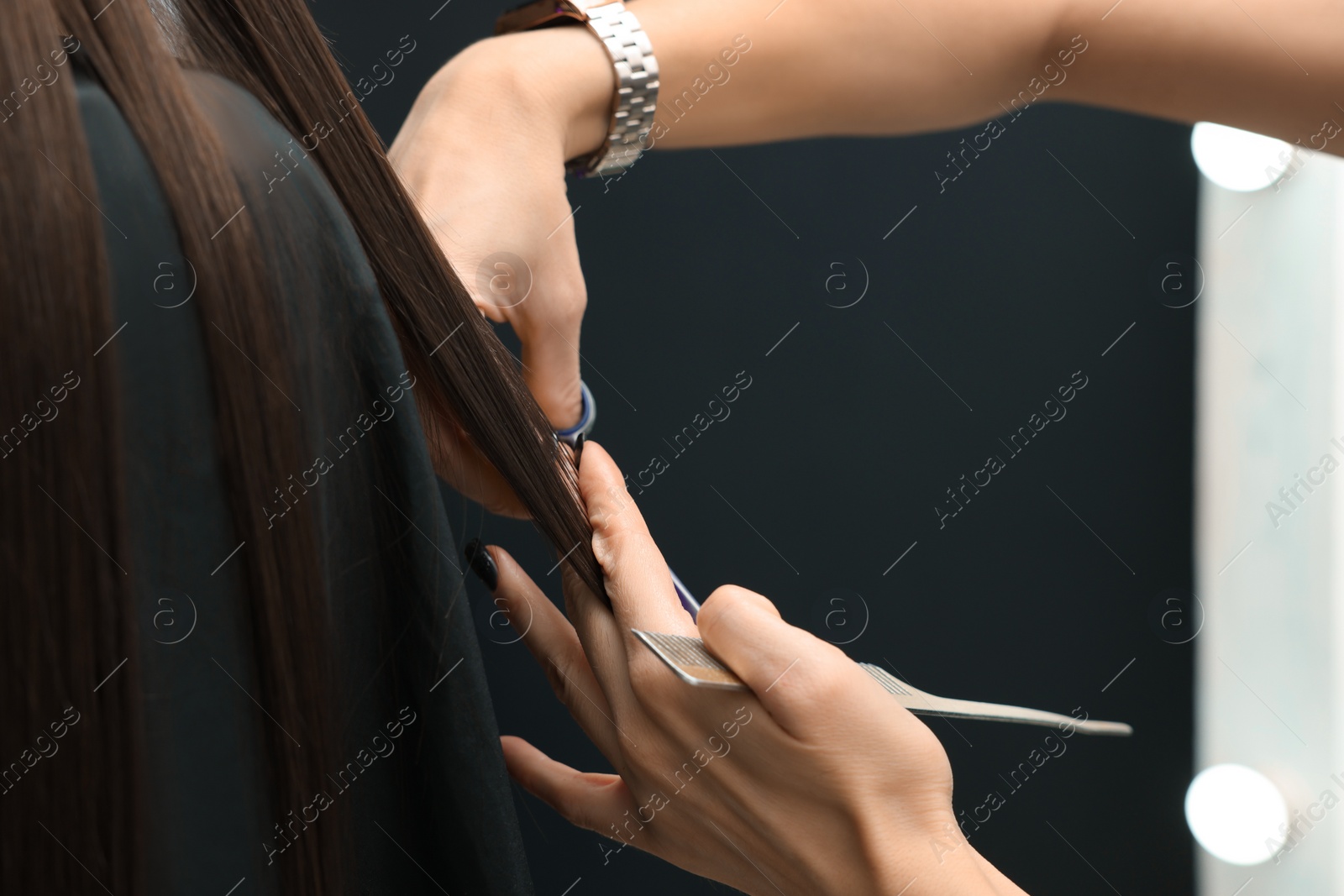 Photo of Professional hairdresser cutting woman's hair, closeup view