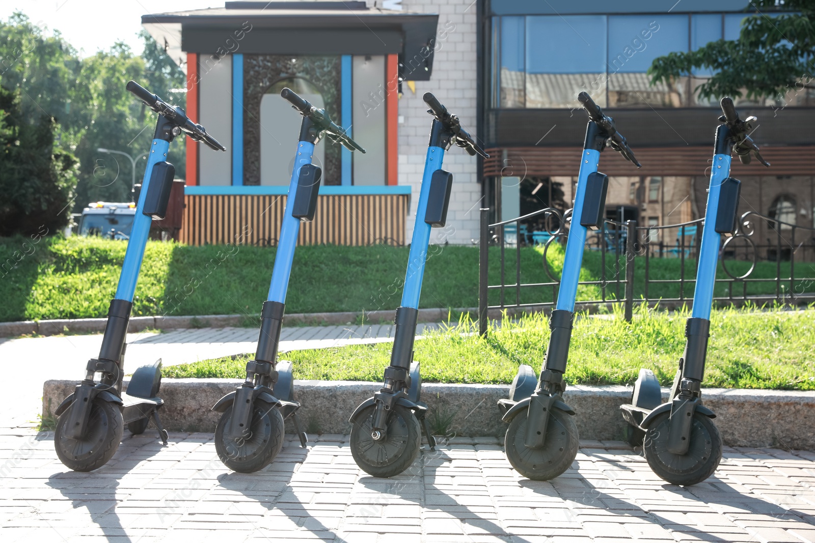 Photo of Many modern electric scooters parked on city street. Rental service