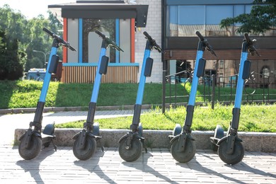 Many modern electric scooters parked on city street. Rental service