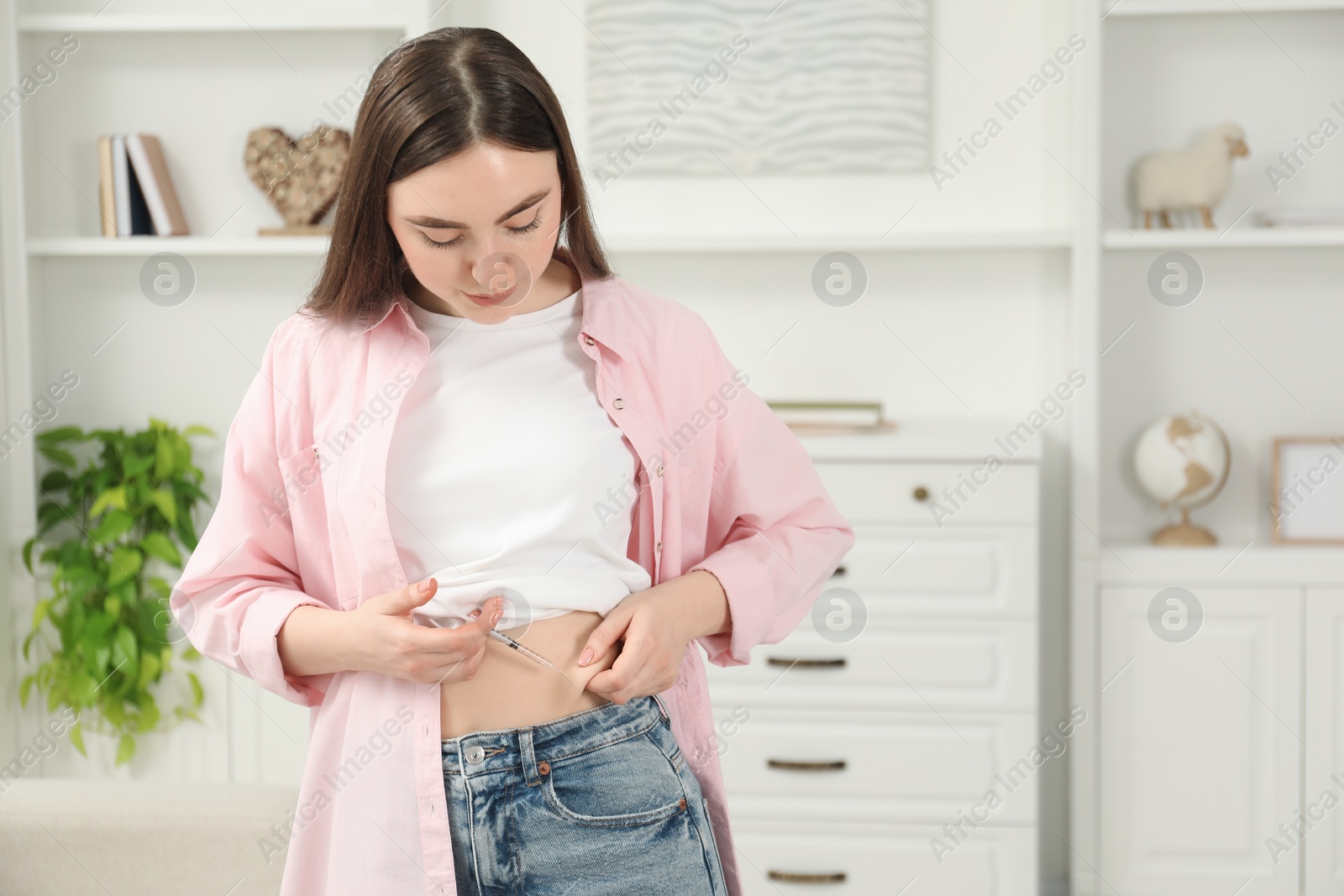 Photo of Diabetes. Woman making insulin injection into her belly at home, space for text