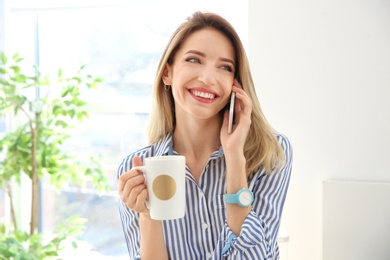 Young woman talking on phone indoors