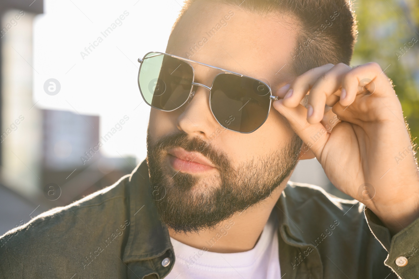 Photo of Handsome young man in sunglasses outdoors, closeup