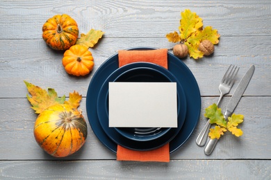 Festive table setting on light wooden background, flat lay with space for text. Thanksgiving Day celebration