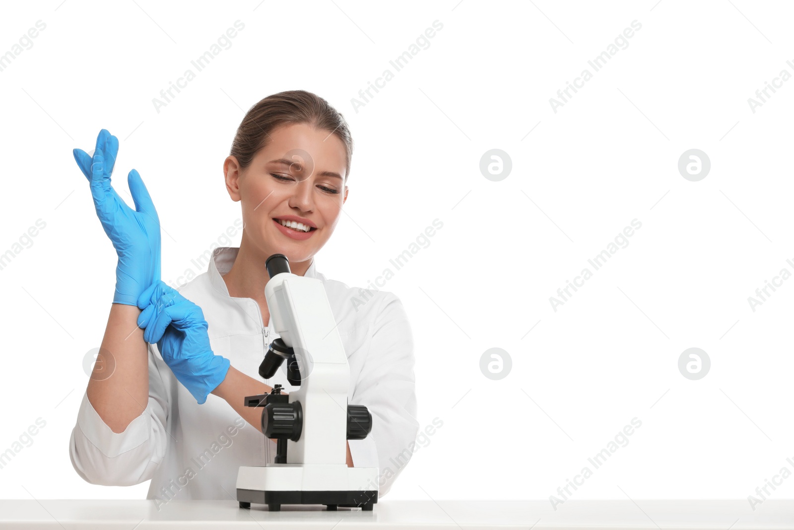 Photo of Woman with modern microscope at white table isolated on white. Medical research