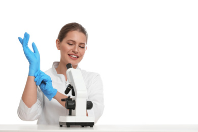 Photo of Woman with modern microscope at white table isolated on white. Medical research