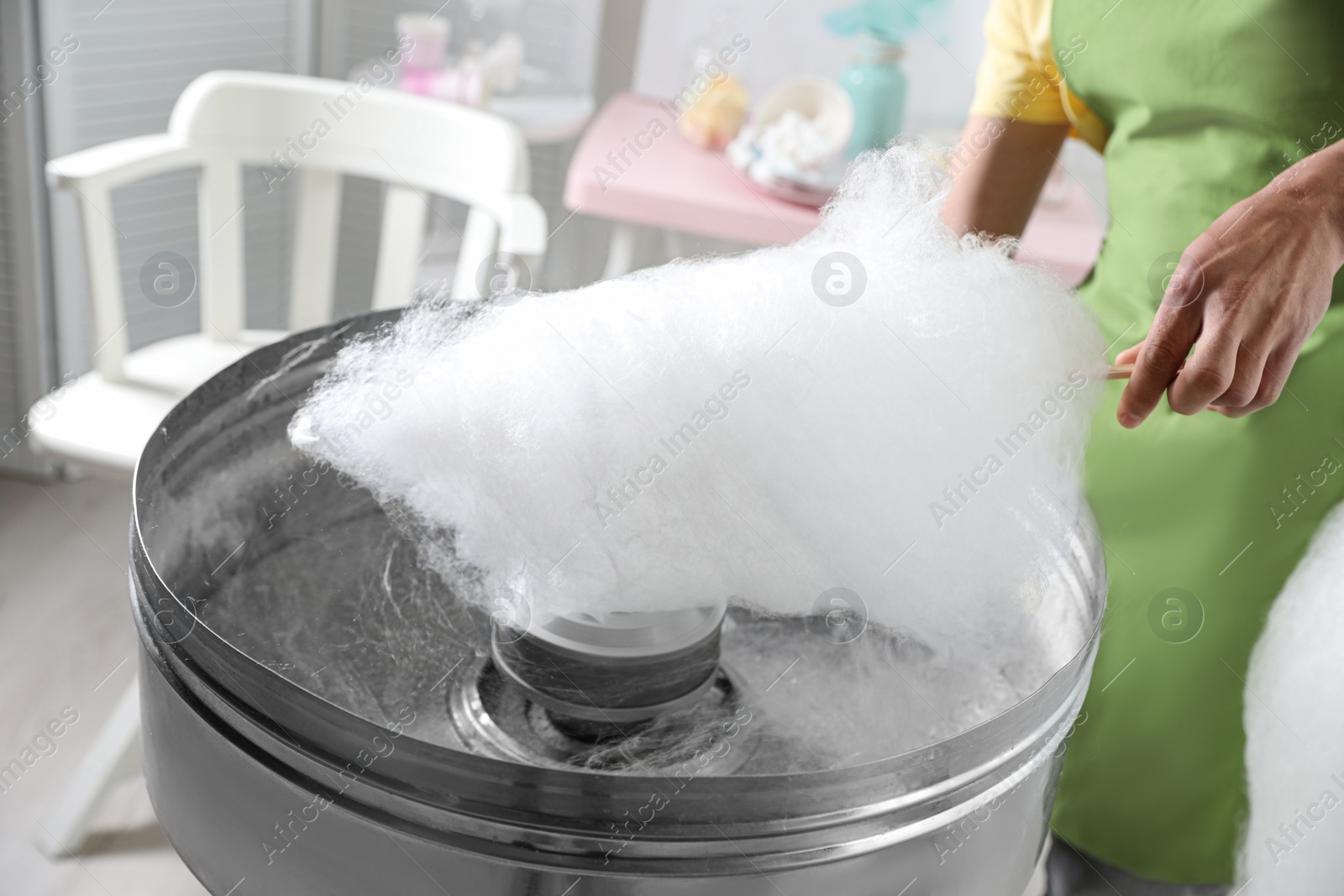 Photo of Woman making cotton candy using modern machine indoors, closeup