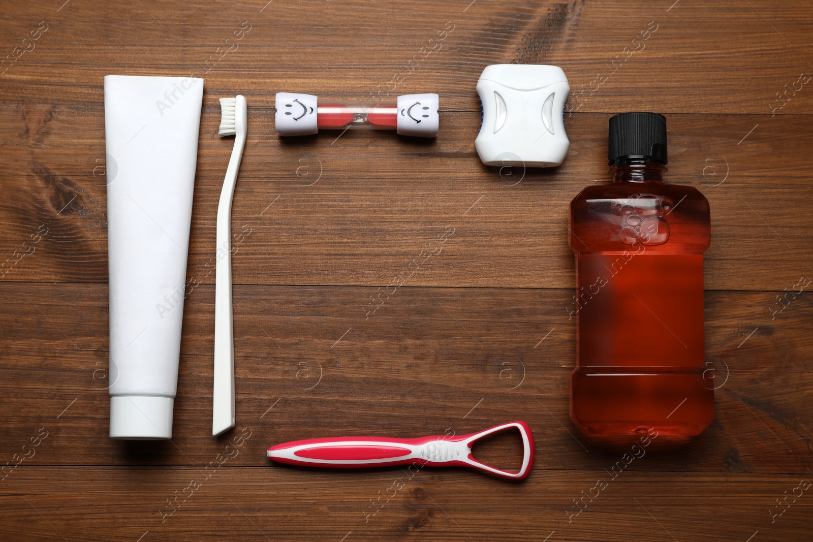 Photo of Frame of tongue cleaner and teeth care products on wooden table, flat lay. Space for text