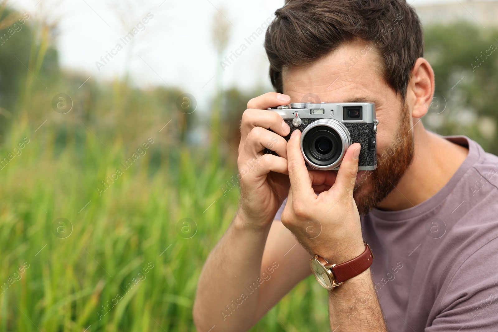 Photo of Man with camera taking photo outdoors, space for text. Interesting hobby