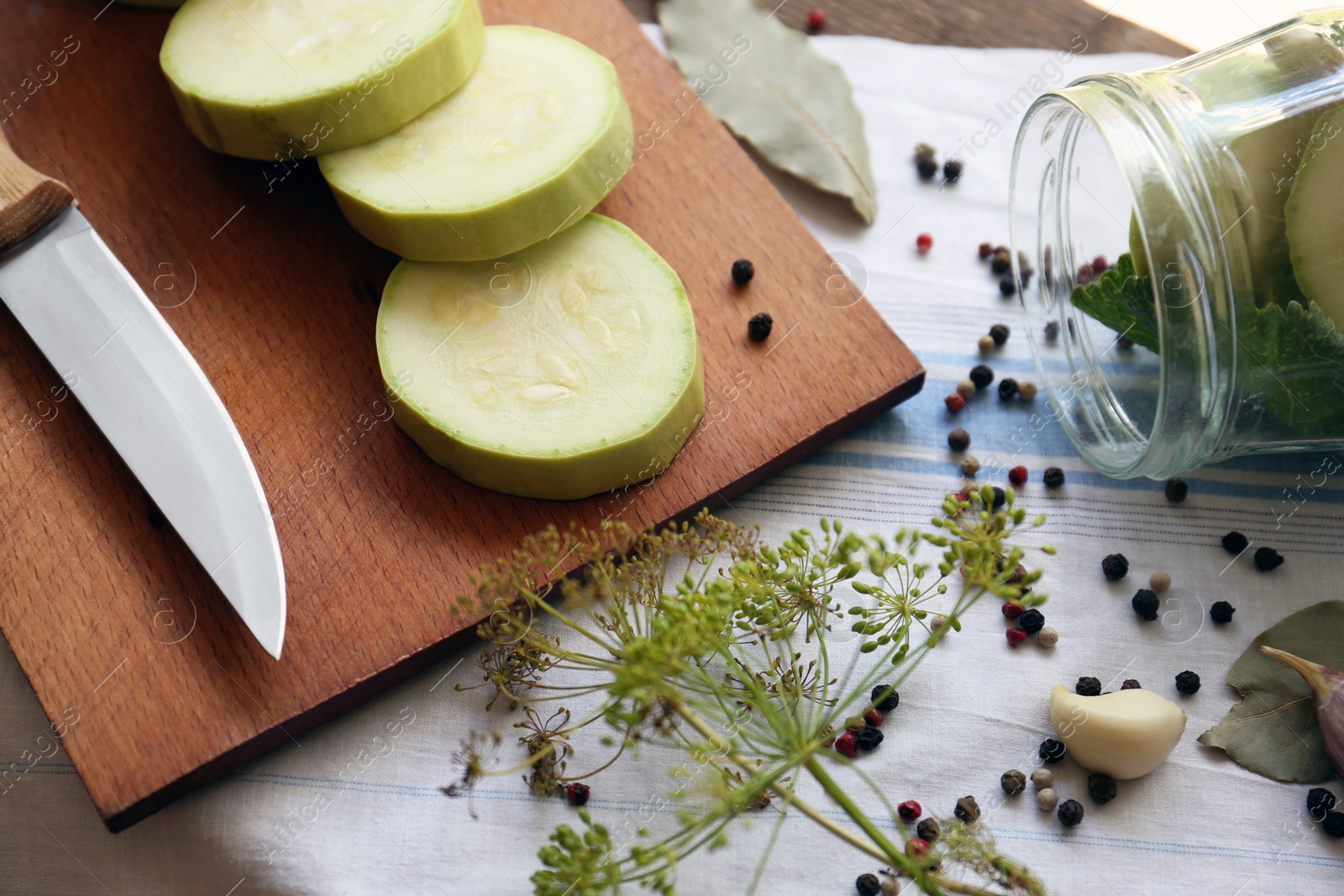 Photo of Cut fresh zucchini and other ingredients on table, closeup. Pickling vegetables