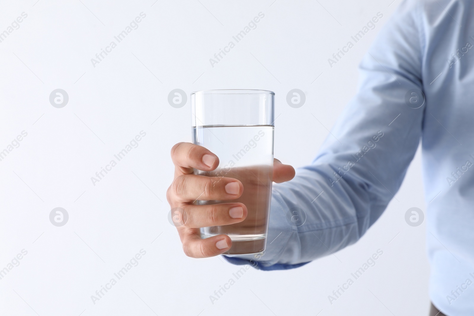 Photo of Man holding glass of pure water on white background, closeup. Space for text